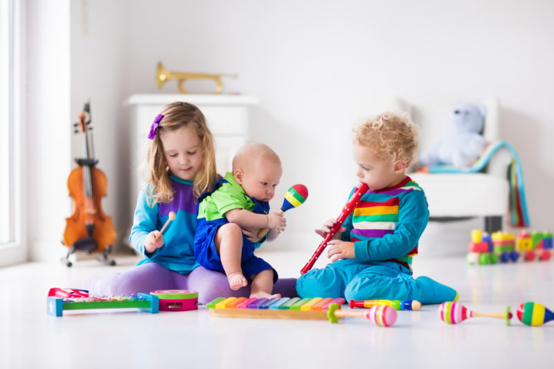 three children playing music instruments